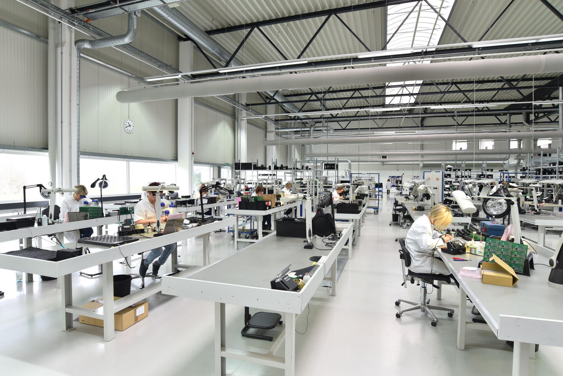 engineering in microelectronics: workers in the production and assembly of electronic high tech components in a modern factory